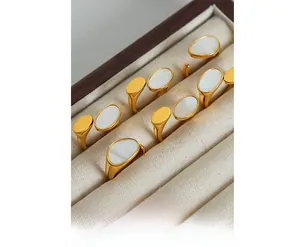 Detail of gold-plated rings with oval white mother of pearl inlays in a gift box