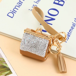 Close-up of brown leather coin purse keychain with rhinestones and tassel decoration