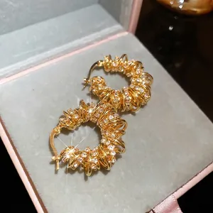 Boucles d'oreilles créoles torsadées plaquées or avec pavé de zircons étincelants