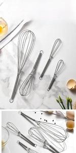 Detailed set of four stainless steel wire whisks with anti-slip spring handles on marble