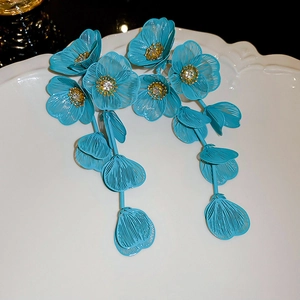 Detail of teal wire-mesh flower tassel earrings with sparkling cubic zirconia centers