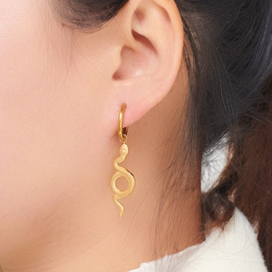 Gold snake-shaped earrings with fine skin texture on a female model for a luxury look