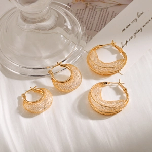 Elegant gold hollow mesh crescent earrings in two sizes on minimalist background
