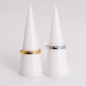 Luxe gold and silver wave couple rings set with pavé cubic zirconia on white stands