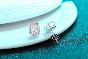 Macro shot of S925 silver stud earrings with Radiant cut emerald moissanite and halo