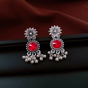 Detailed close-up of retro silver flower earrings with red crystal and metallic tassels