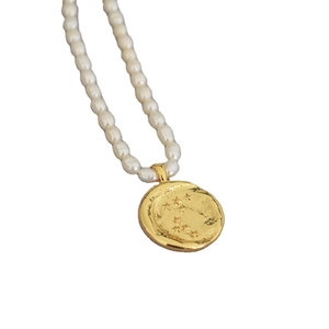 Vintage freshwater pearl necklace with gold star coin pendant on a clean background