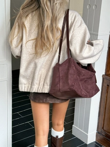 Detailed back view of a dark brown suede tote bag styled with a casual autumn outfit