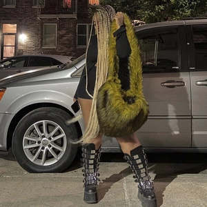 Olive green faux fur crossbody bag and black platform boots in a trendy street style
