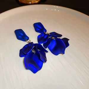 Macro detail of royal blue layered petal earrings with matte finish on white tray
