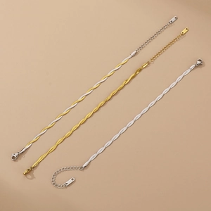 Close-up of three braided snake chain bracelets in gold and silver with lobster clasps