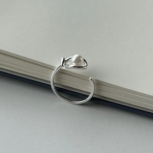 Detailed view of 925 sterling silver minimalist ring with white pearl on book edge