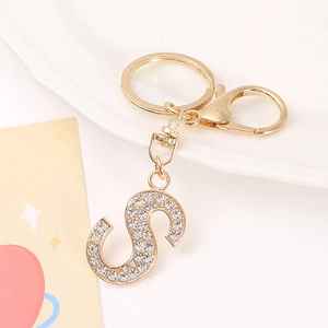 Macro detail of gold letter S keychain with rhinestones and lobster clasp hardware