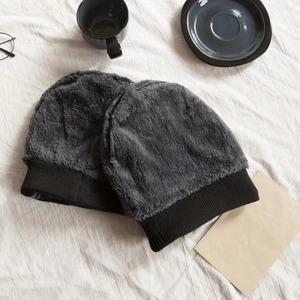 Detailed close-up of fuzzy knit beanies with warm fleece lining and black ribbed cuff