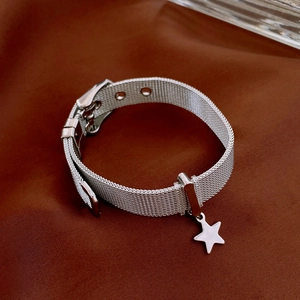 Detailed macro view of silver mesh star bracelet with adjustable watch-style buckle