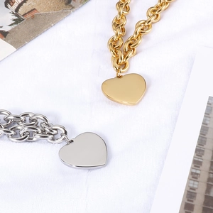 Detailed shot of gold and silver heart necklaces with chunky chains on white fur