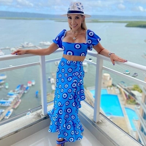 Detalle de conjunto azul con estampado ojo turco, top corto, falda con abertura y sombrero