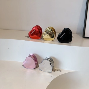 Mini heart-shaped patent leather chain bags in five metallic colors on a white display