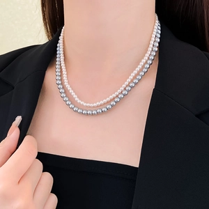 Close-up of elegant double-layer grey and white pearl necklace worn on a model