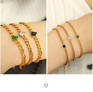 Detail von 18K vergoldeten Kettenarmbändern mit smaragdgrünen und schwarzen Edelsteinen