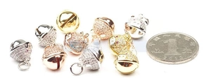 Close-up of DIY pavé bell pendants in gold, silver, and rose gold with rhinestones
