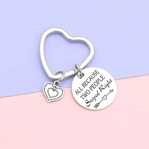 Silver stainless steel keychain set with heart and engraved round pendant on pastel background
