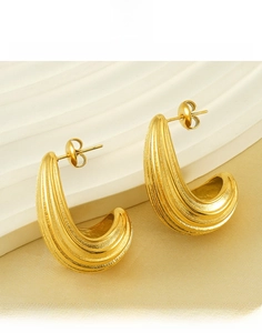 Detailed macro view of 18K gold plated hollow hoop earrings with textured vertical stripes