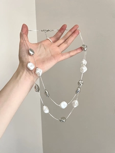 Detailed view of double-layer vintage necklace with irregular white pearls and silver beads