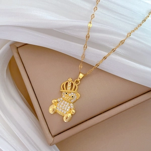 Luxurious gold titanium bear necklace with crown and sparkling crystals on a gift box