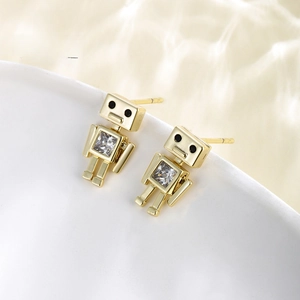 Detailed close-up of 14K gold plated robot stud earrings with cubic zirconia on white ceramic