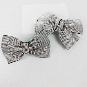 Elegant silver bow hair clip with sparkling rhinestones on a minimalist background