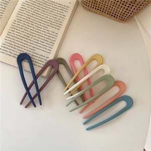 Flat lay of 9 matte Morandi color U-shaped hair pins arranged in a stylish fan shape