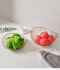 Close-up of golden wavy wire fruit baskets featuring modern minimalist metal craftsmanship