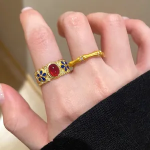 Close-up of vintage gold S925 silver ring with red ruby gemstone and enamel bamboo details