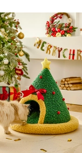 Detail der weihnachtsbaumförmigen Katzenhöhle aus grünem Plüsch mit roten Schleifen