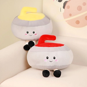 Peluche créative en forme de pierre de curling avec visages brodés sur un canapé