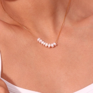 Detalle del collar de acero inoxidable chapado en oro de 18K con ocho perlas de agua dulce