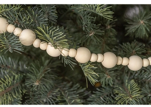 Close-up of rustic natural wood bead garland draped on a green Christmas tree branch