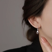 Close-up of elegant double heart hoop earrings with silver finish on model