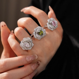 Macro view of three floral zircon rings with pink, green and clear oval gemstones