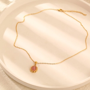 Detail of pink cat-eye stone pendant on thin gold titanium steel chain for women