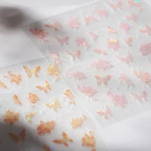 Macro view of iridescent butterfly and flower nail art stickers with laser holographic finish