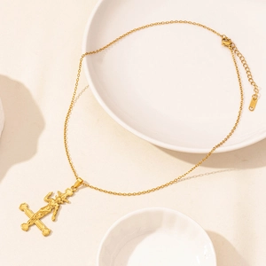 Macro shot of 18K gold plated stainless steel inverted cross pendant with goat relief