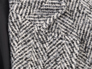 Détail macro du manteau en tweed gris à chevrons avec tissu épais en laine