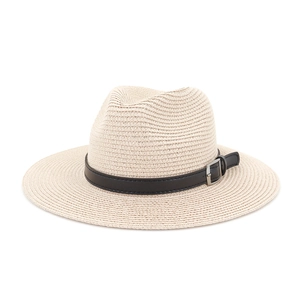 Detailed close-up of woven straw sun hat texture with black leather buckle strap