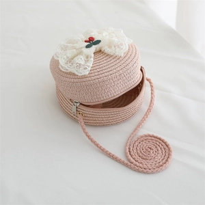 Detail of pink straw crossbody bag with white lace bow and cherry embroidery for girls