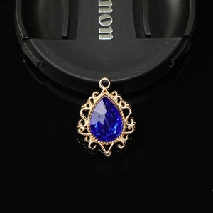 Vue macro d'un pendentif doré avec pierre bleue et design ajouré en dentelle