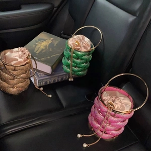Macro detail of rhinestone bucket bags with woven metal cages and silk drawstrings