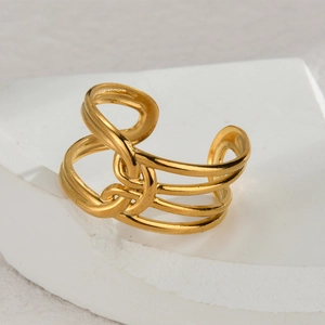 Minimalist knot design gold stainless steel open ring shown on a white stone base