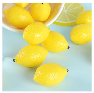 Close-up of artificial mini yellow lemons with realistic texture on a blue background